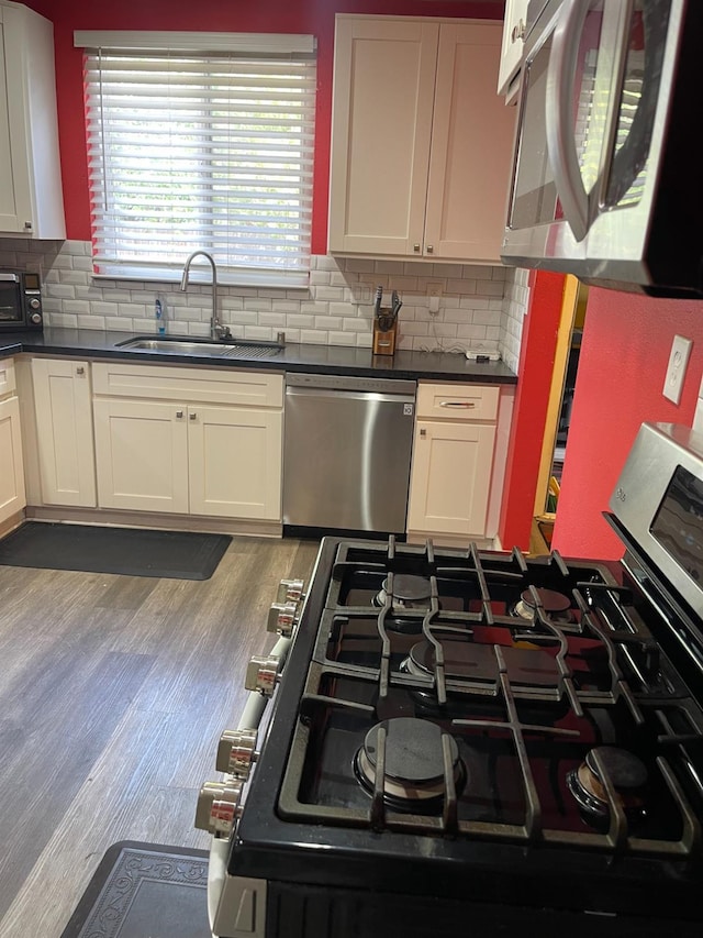 3740 26th Ave, Sacramento, CA 95820 - kitchen featuring appliances with stainless steel finishes, dark countertops, and backsplash
