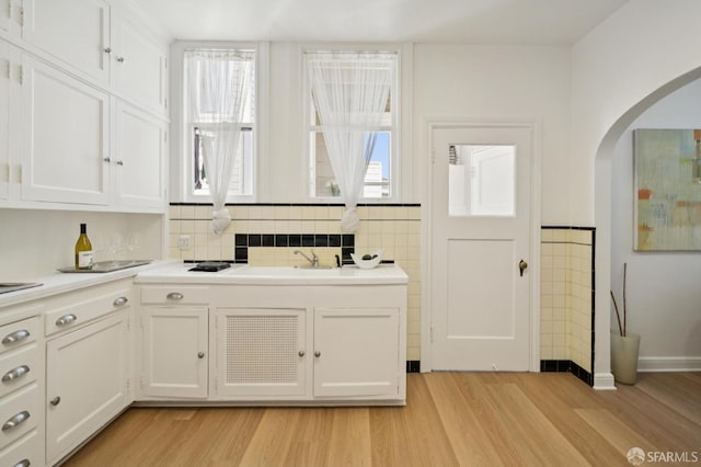 1063-1065 Sanchez St, San Francisco, CA 94114 - kitchen with arched walkways, light wood-style floors, and white cabinets