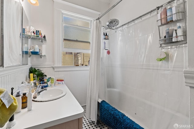 bathroom with wood walls, shower / tub combo with curtain, and vanity