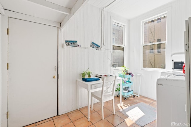 interior space with wooden walls, washing machine and clothes dryer, and radiator