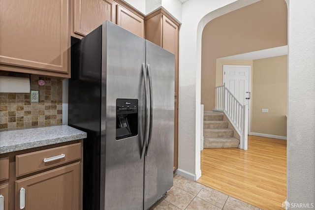 23019 Canyon Terrance Dr Unit U2, Castro Valley, CA 94552 - kitchen featuring stainless steel fridge with ice dispenser, tasteful backsplash, light tile patterned floors, and baseboards