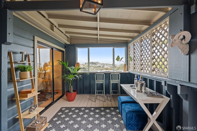 sunroom featuring vaulted ceiling with beams