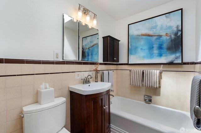 full bathroom featuring a washtub, tile walls, a wainscoted wall, toilet, and vanity