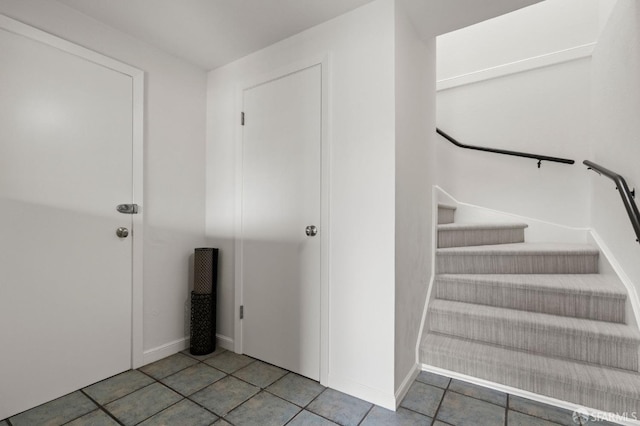 stairway featuring tile patterned flooring and baseboards