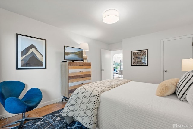 bedroom with baseboards and wood finished floors