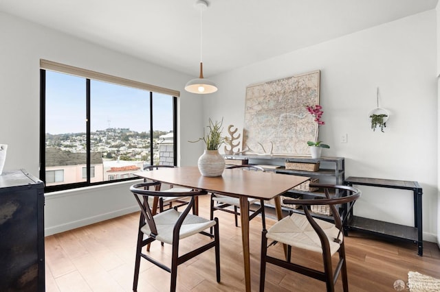 dining space with light wood-style floors and baseboards
