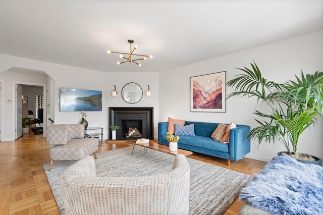 living room with a fireplace, a notable chandelier, and baseboards