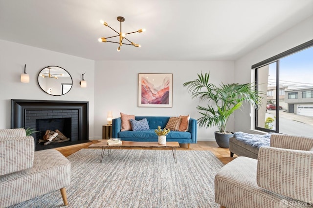 living area with a brick fireplace, a chandelier, and baseboards