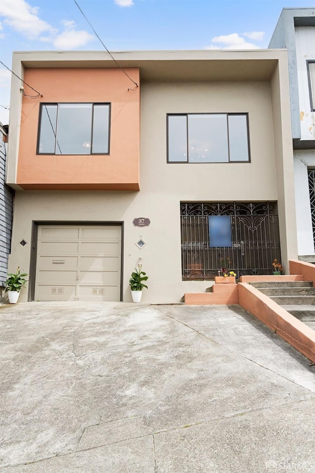 view of front of home with driveway, a garage, and stucco siding