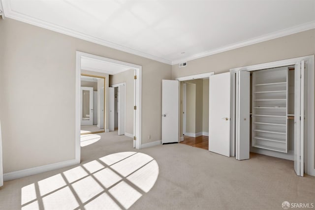 unfurnished bedroom with ornamental molding, light colored carpet, and baseboards