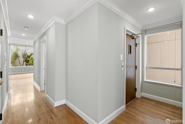 corridor with baseboards, light wood-type flooring, and crown molding