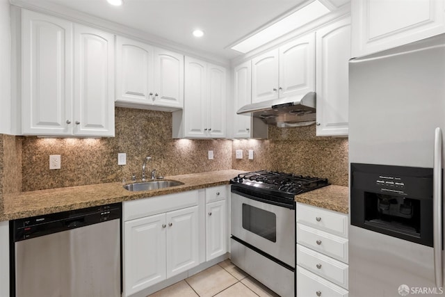 kitchen with light tile patterned flooring, under cabinet range hood, a sink, white cabinets, and appliances with stainless steel finishes