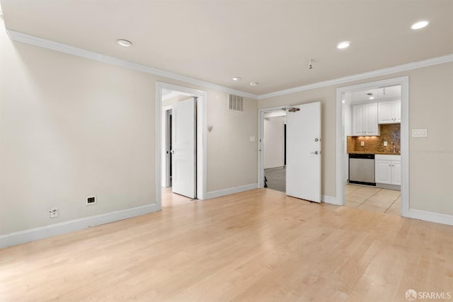 interior space with visible vents, ornamental molding, and light wood-style flooring
