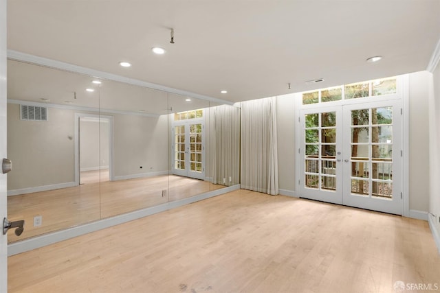empty room featuring recessed lighting, wood finished floors, visible vents, ornamental molding, and french doors