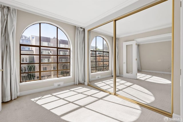 unfurnished room featuring french doors, ornamental molding, carpet, and baseboards