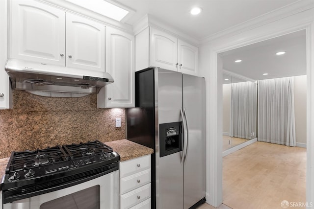 kitchen with light wood-style flooring, under cabinet range hood, stainless steel appliances, white cabinets, and tasteful backsplash
