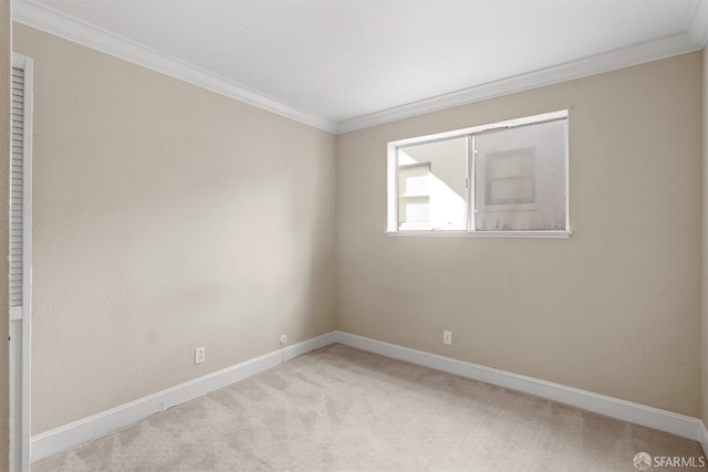 carpeted empty room featuring baseboards and crown molding