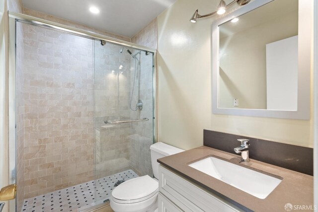 bathroom featuring a stall shower, vanity, and toilet