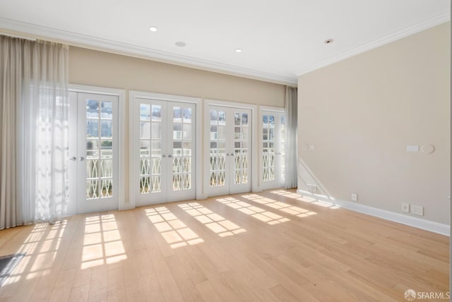 spare room with light wood-style flooring, recessed lighting, baseboards, ornamental molding, and french doors