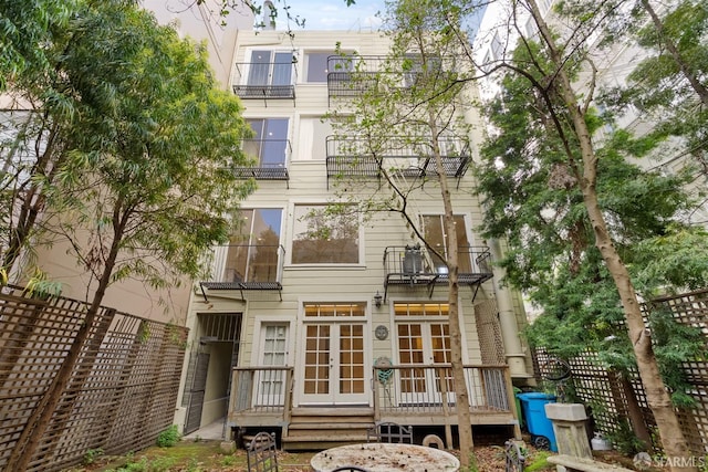 back of property featuring french doors and fence