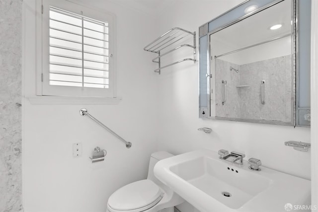 bathroom featuring a shower, a sink, and toilet