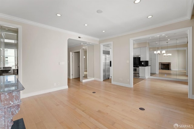 unfurnished living room with light wood finished floors, baseboards, crown molding, and recessed lighting