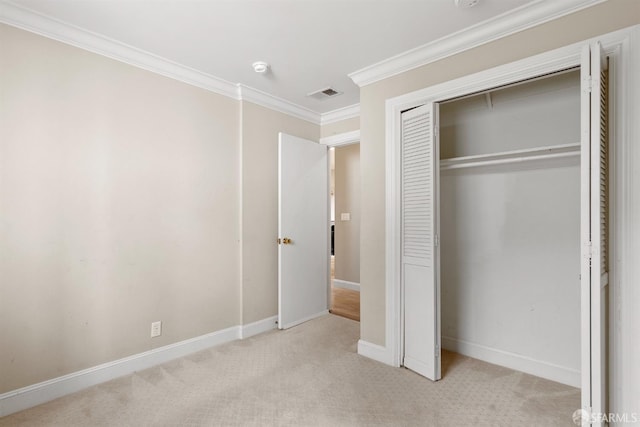 unfurnished bedroom with carpet floors, visible vents, baseboards, ornamental molding, and a closet