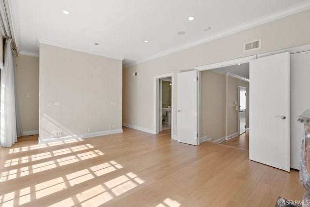 unfurnished bedroom with baseboards, ornamental molding, visible vents, and light wood-style floors