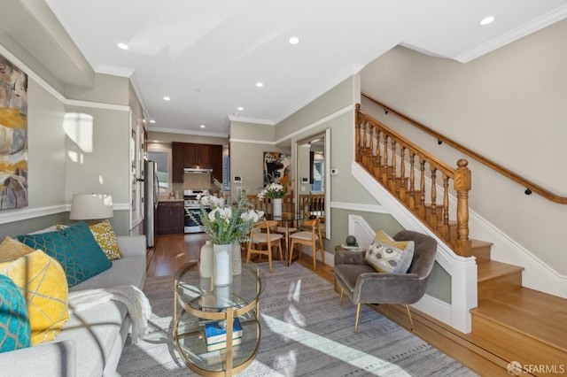 living room featuring recessed lighting, wood finished floors, stairs, and crown molding