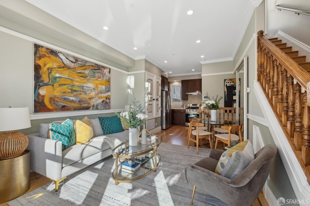 living room featuring crown molding, stairway, recessed lighting, and light wood-type flooring