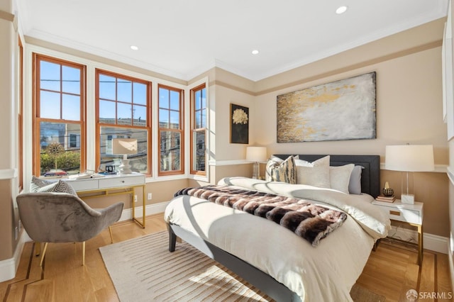 bedroom featuring light wood finished floors, baseboards, and ornamental molding