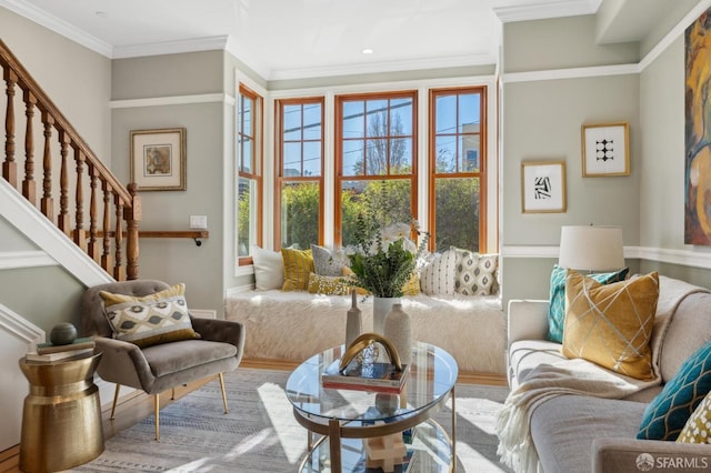 living area featuring stairway, baseboards, and ornamental molding