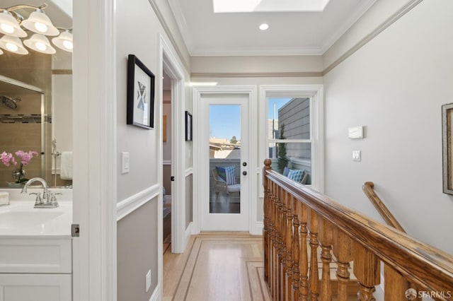 corridor featuring french doors, crown molding, and a sink