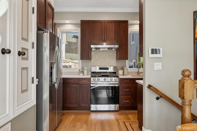 kitchen featuring extractor fan, ornamental molding, light countertops, and stainless steel appliances