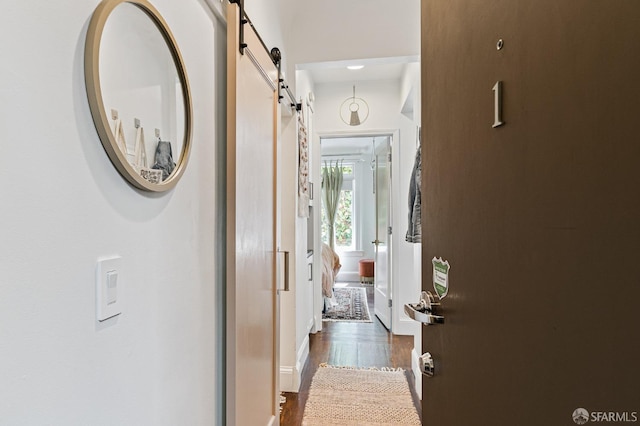 hallway featuring dark hardwood / wood-style flooring and a barn door