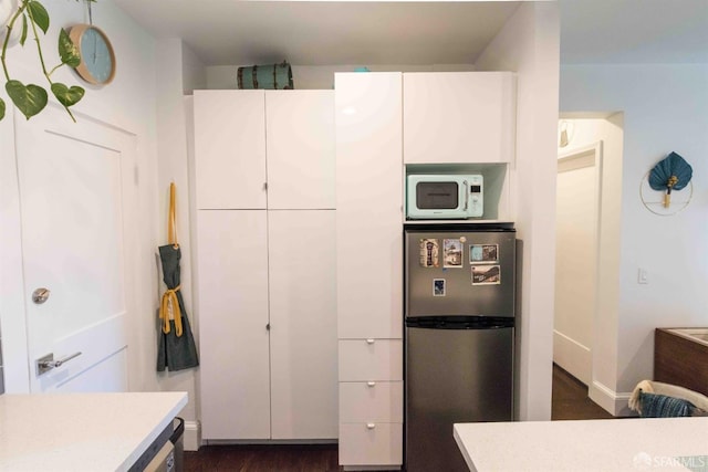 kitchen featuring white cabinets, dark hardwood / wood-style floors, and stainless steel refrigerator