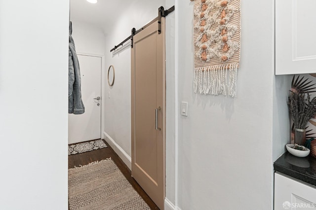 hall featuring dark hardwood / wood-style flooring and a barn door