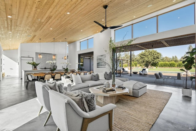 living room featuring concrete flooring, a towering ceiling, and wooden ceiling