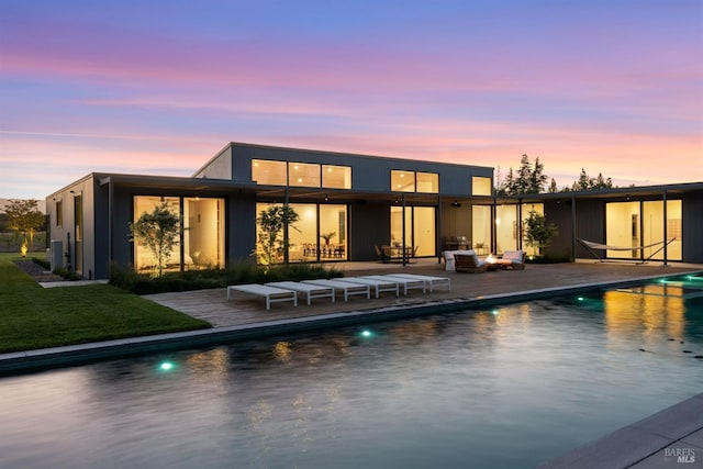 back house at dusk with a patio area