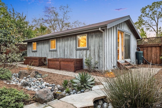 view of property exterior featuring board and batten siding and fence