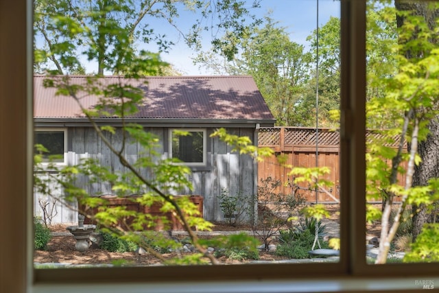 view of home's exterior with metal roof and fence