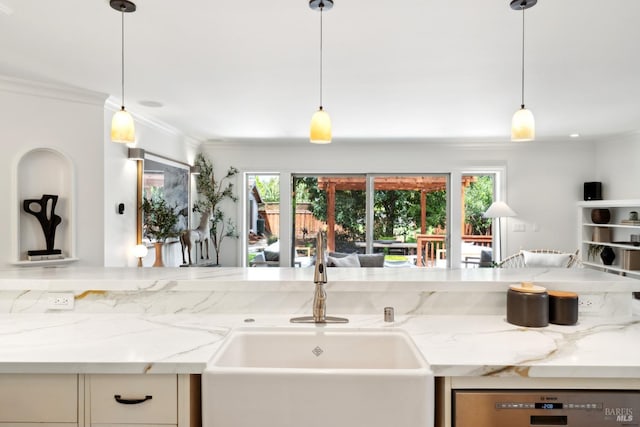 kitchen featuring a sink, a wealth of natural light, crown molding, and light stone countertops