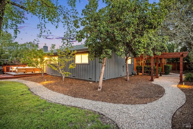 yard at dusk with an outdoor living space, a pergola, fence, and a deck