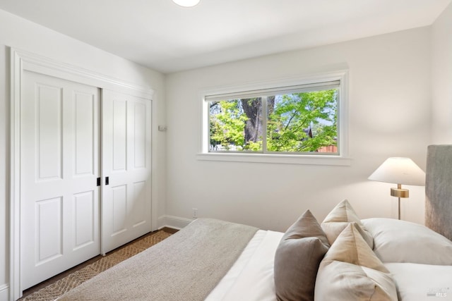 bedroom featuring a closet, baseboards, and carpet