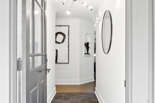 corridor with stone finish flooring, baseboards, and ornamental molding