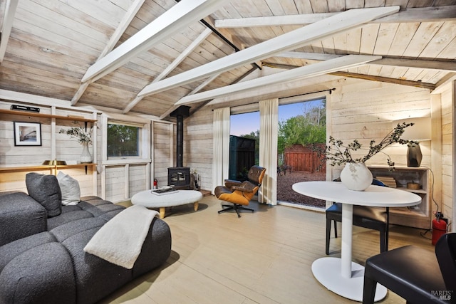 living area with wooden ceiling, a wood stove, wood finished floors, wood walls, and vaulted ceiling with beams