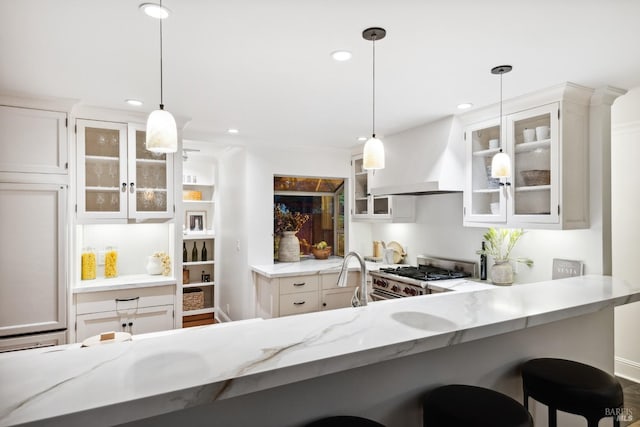 kitchen with custom exhaust hood, recessed lighting, stainless steel gas stove, and light stone counters