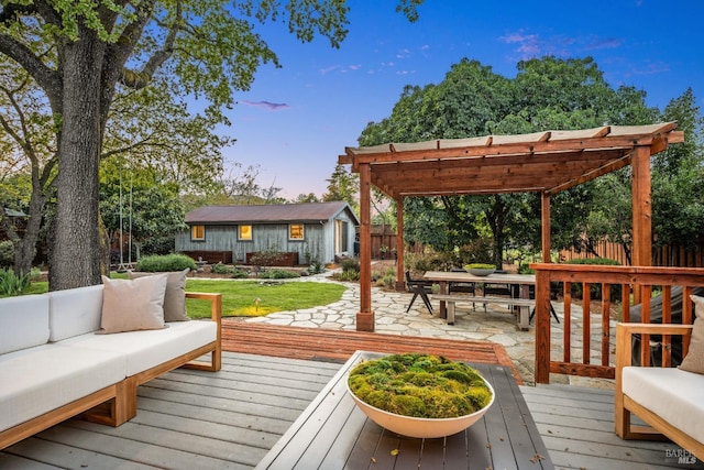 deck at dusk with a pergola, an outdoor living space, fence, and an outbuilding