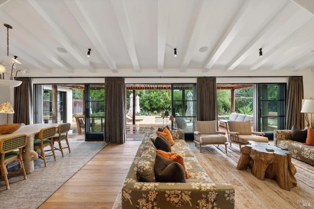 living area with light wood-style floors and beam ceiling