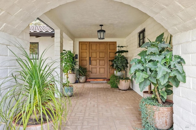 property entrance with a tile roof and stucco siding